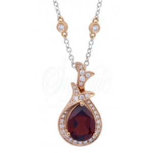 A red garnet pendant set in 18k rose gold framed by white diamonds by Supreme Jewelry 