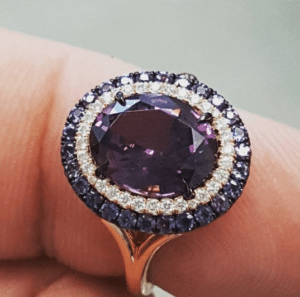 Oval cut purple spinel framed by diamonds and alexandrite, by Omi Privé.