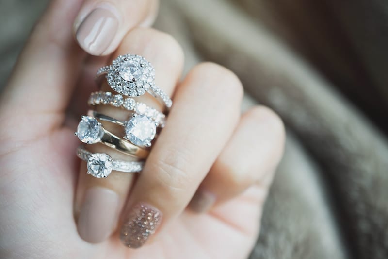 5 diamond rings on one woman's finger