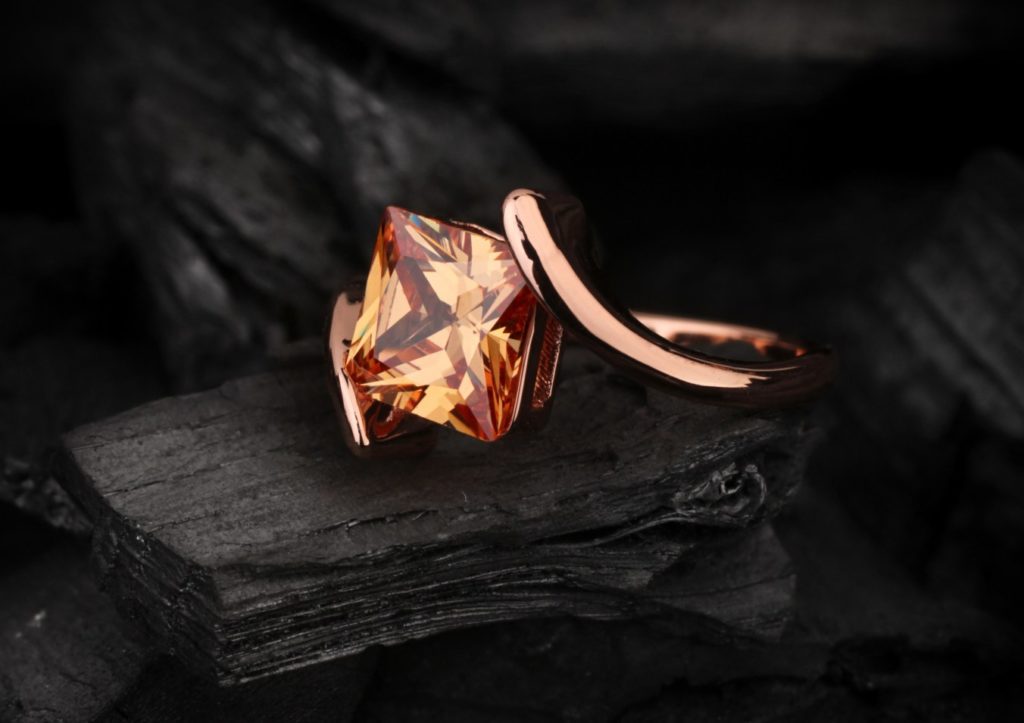 jewelry ring with big topaz gem on black coal background