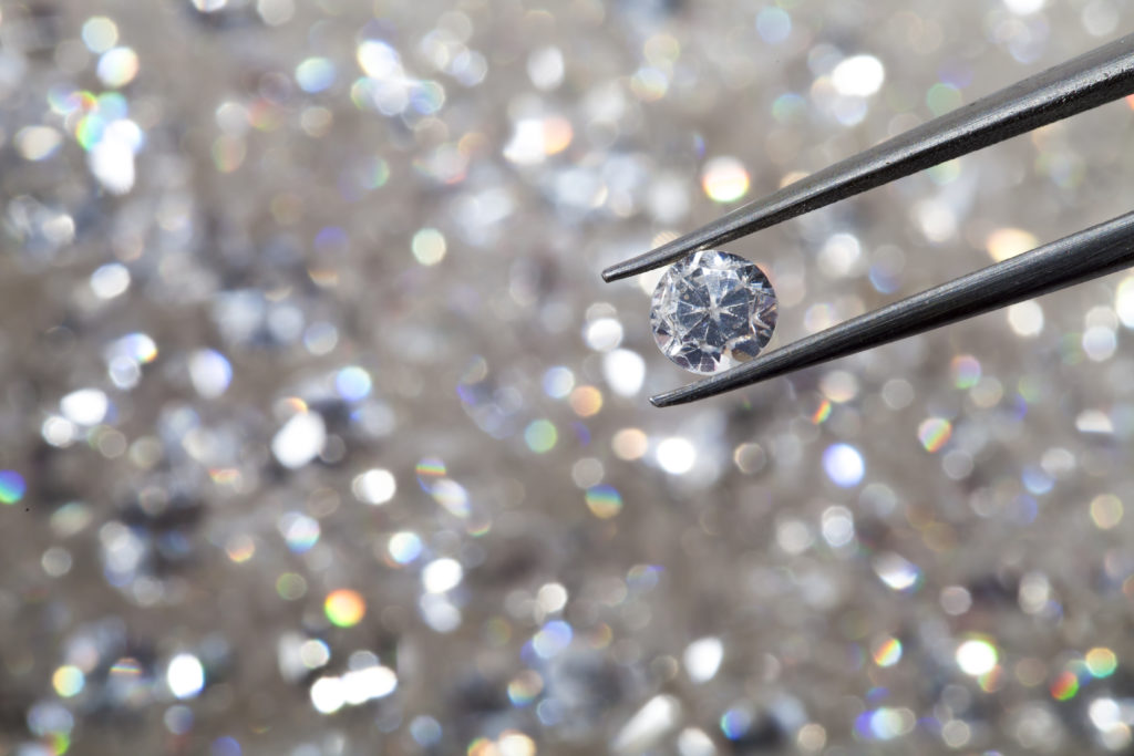 Diamond held in tweezers with more diamonds out of focus