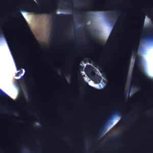 These growth remnants in a laboratory-grown diamond have dark relief, graphitized centers and discoid stress fractures.
