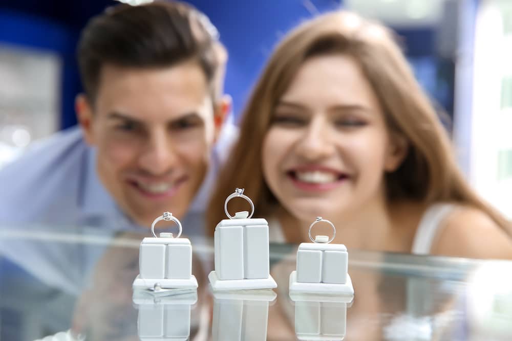 Young couple choosing engagement ring in jewelry store