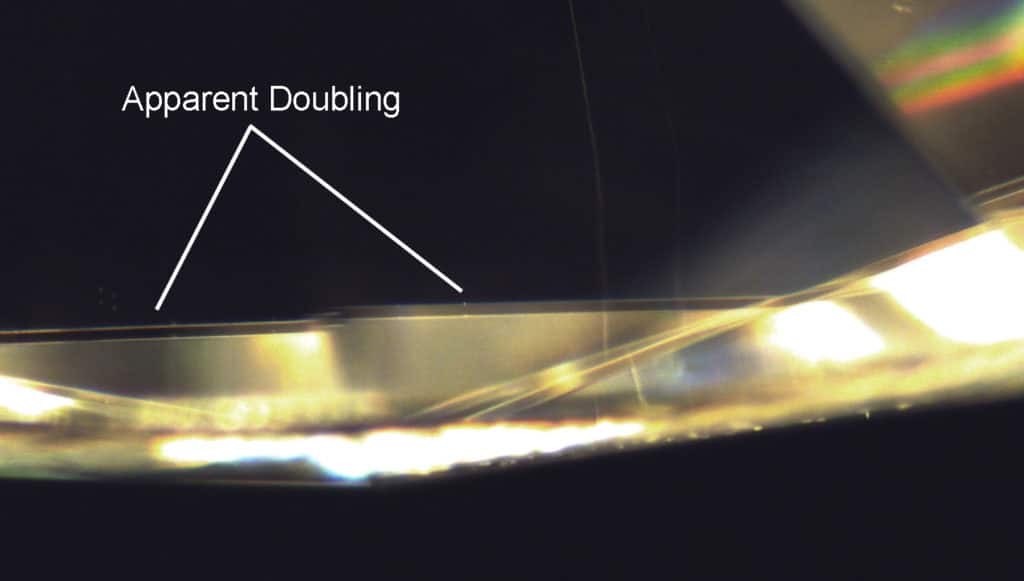 Apparent doubling of a facet junction as observed through the pavilion of the gemstone.