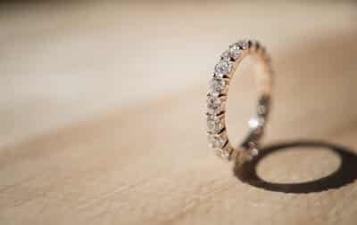 Elegant diamond ring on wooden background_m