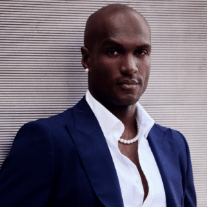 Man wearing pearl necklace and pearl earrings.