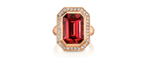 An emerald-cut orange-red tourmaline ring with a diamond halo in rose gold.