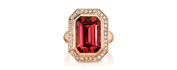 An emerald-cut orange-red tourmaline ring with a diamond halo in rose gold.
